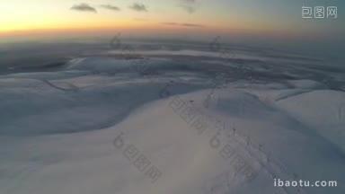 冬天在khibiny上空航拍日落或日出，山上有滑雪缆车